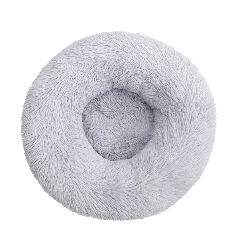 Round donut dog bed in silver grey shaggy plush, a pale grey with a deep central hollow, seen from above