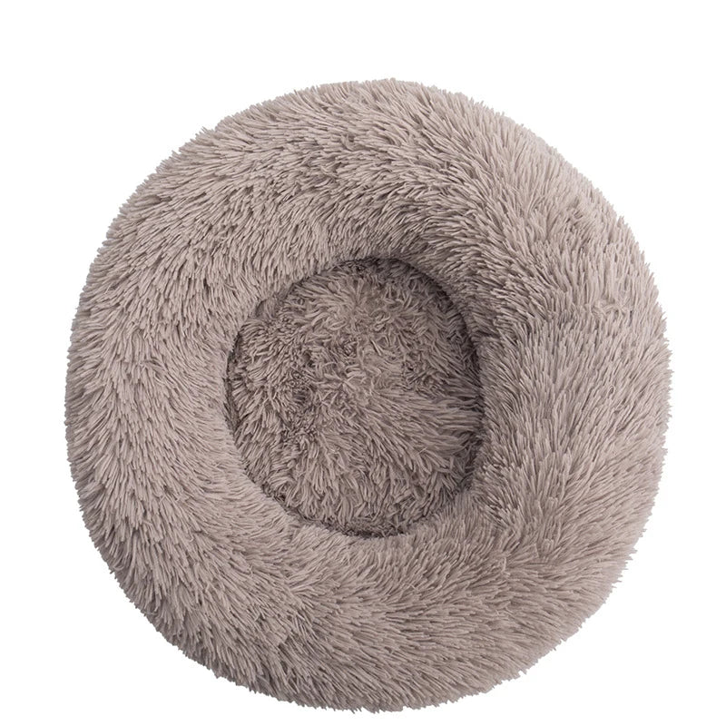 Round donut dog bed in taupe shaggy plush, a greyish brown with a deep central hollow, seen from above