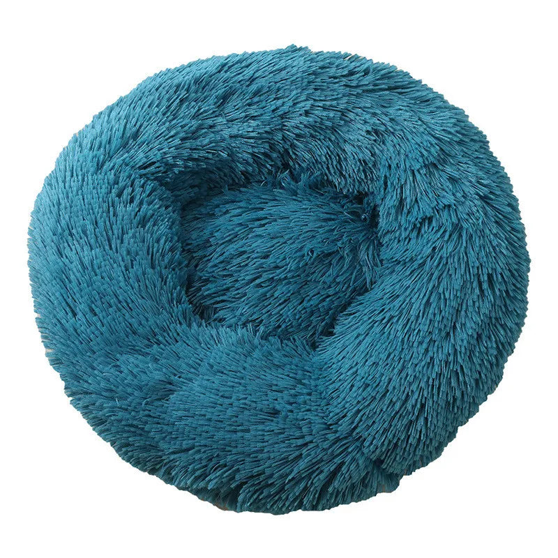 Round donut dog bed in teal shaggy plush, a deep blue-green with a raised rim, seen from above