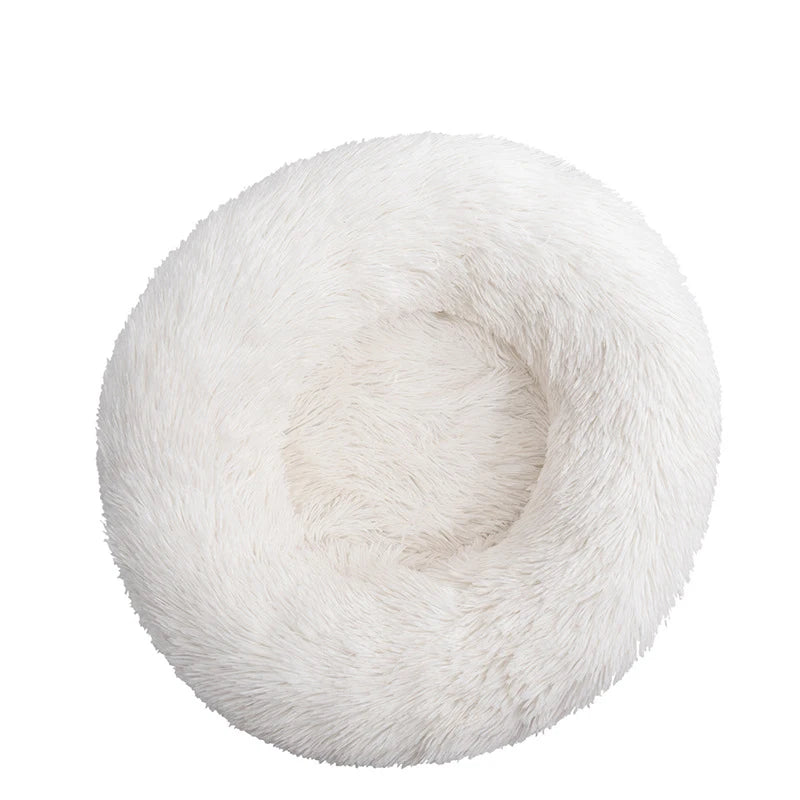 Round donut dog bed in white shaggy plush, pure white with a deep central hollow, seen from above
