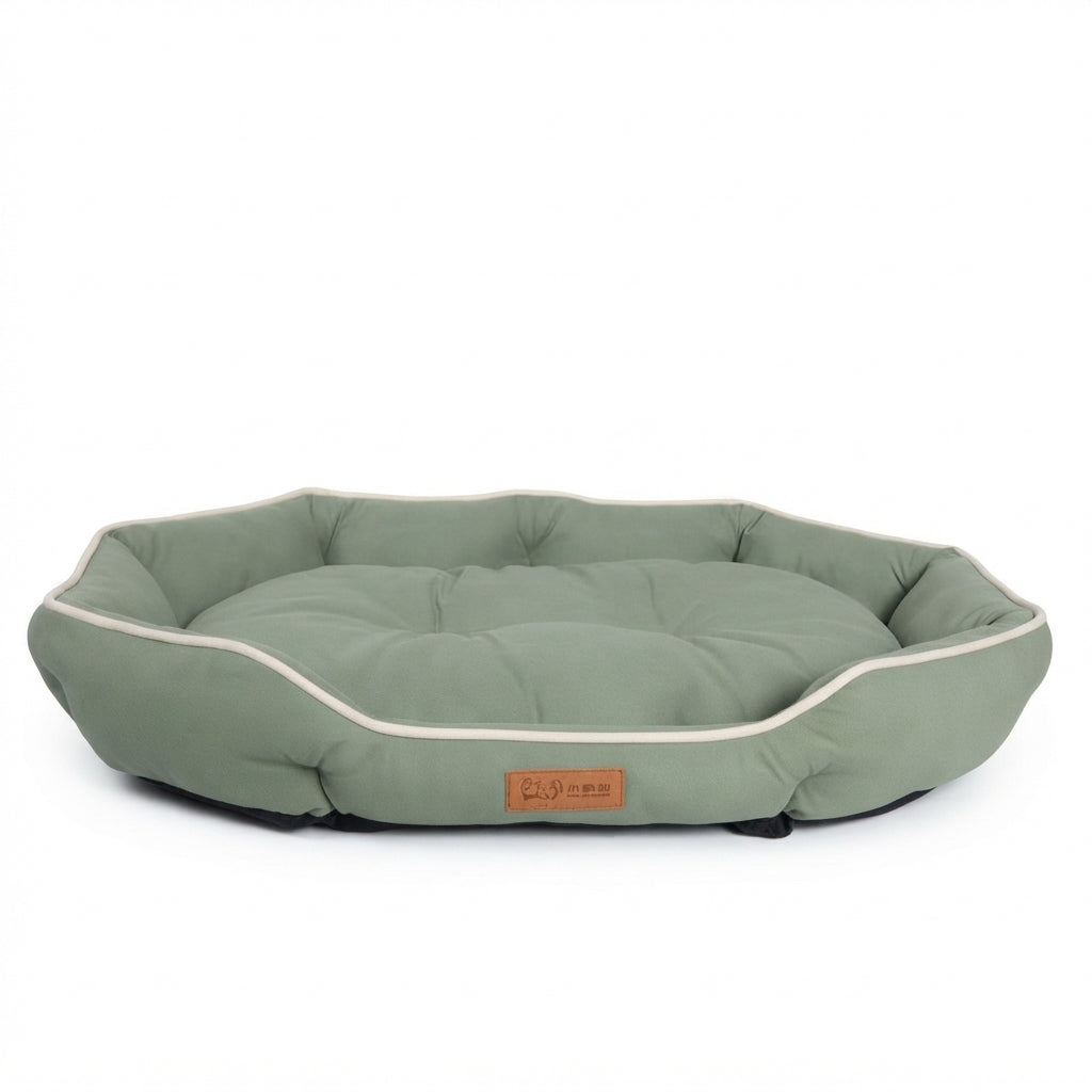 Octagonal dog bed in sage green fabric with cream piping and a padded rim around a tufted cushion