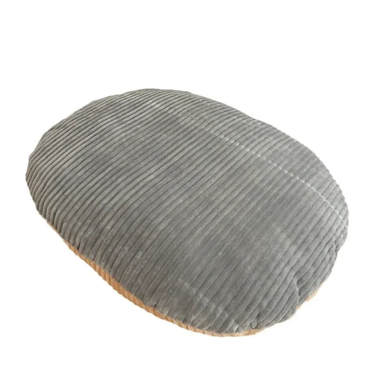 Oval cushion on its own in grey ribbed corduroy plush, with a beige underside