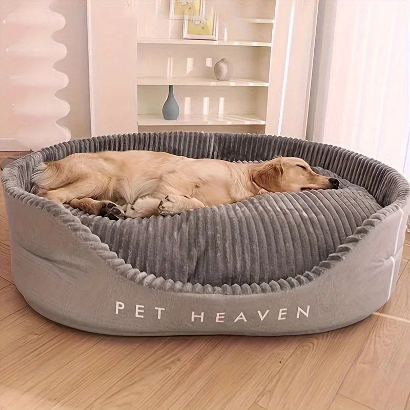 Golden retriever asleep in a large grey oval dog bed with raised ribbed sides, on a wooden floor