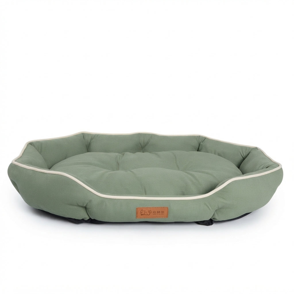 Small oval dog bed in sage green suede-look fabric with cream piping and a padded cushion inside