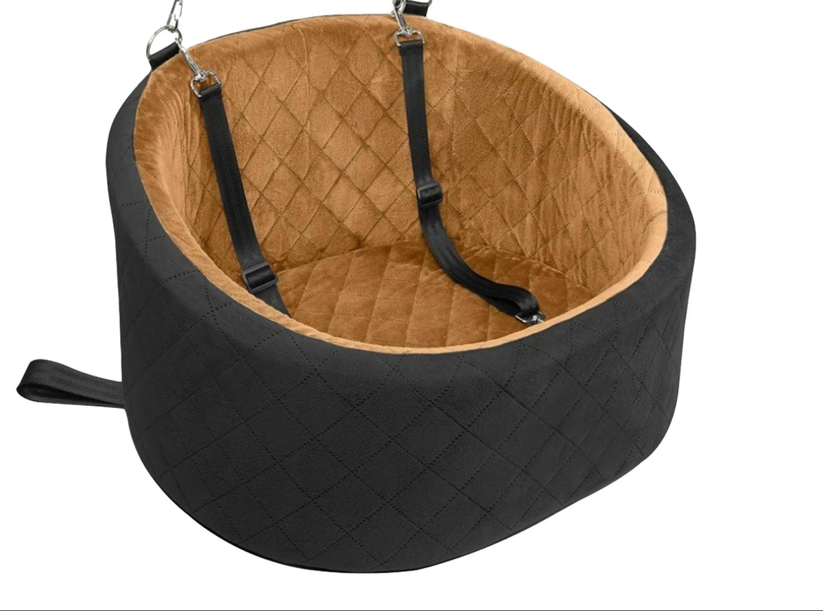 Oval travel dog bed with a black diamond-quilted outside and a tan lining, fitted with two black straps and clips