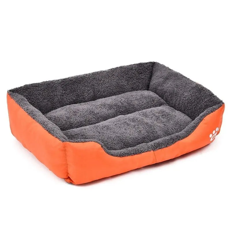Paws dog bed in orange Oxford cloth, a rectangular bed with a grey plush lining and a white paw print, seen at an angle