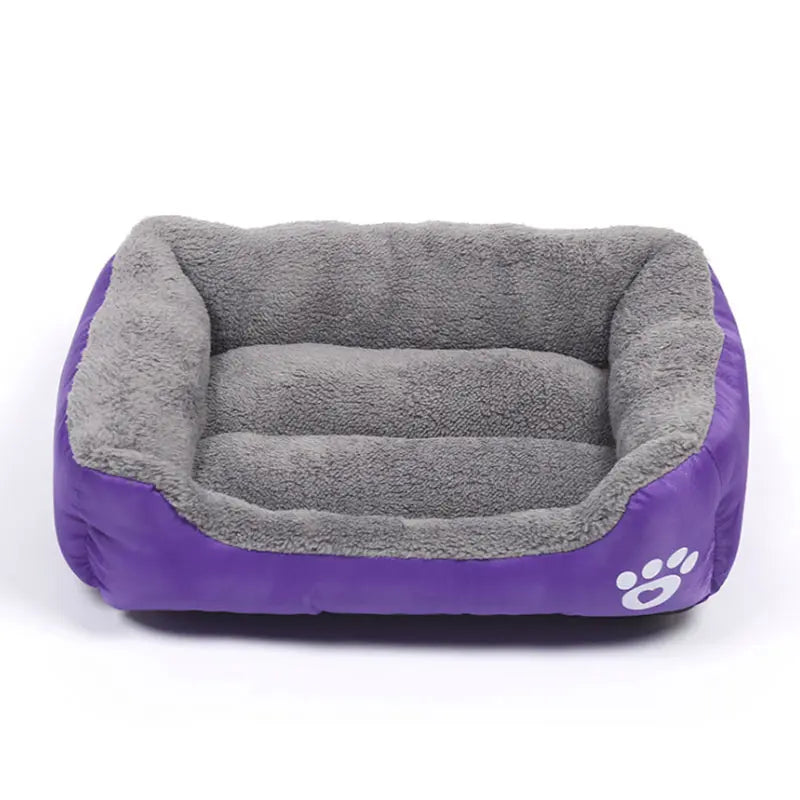 Rectangular dog bed in purple Oxford cloth with a grey plush lining and a white paw print on the front corner