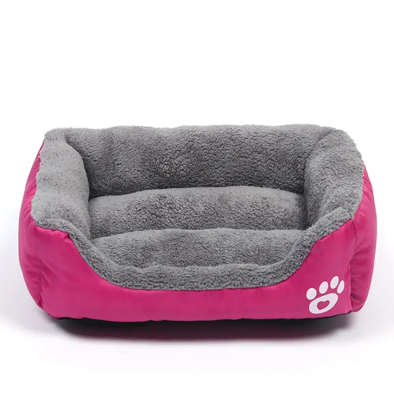 Rectangular dog bed in rose red Oxford cloth with a grey plush lining, low front edge and a white paw print