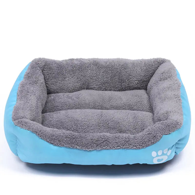 Rectangular dog bed in sky blue Oxford cloth with a thick grey plush lining and a white paw print