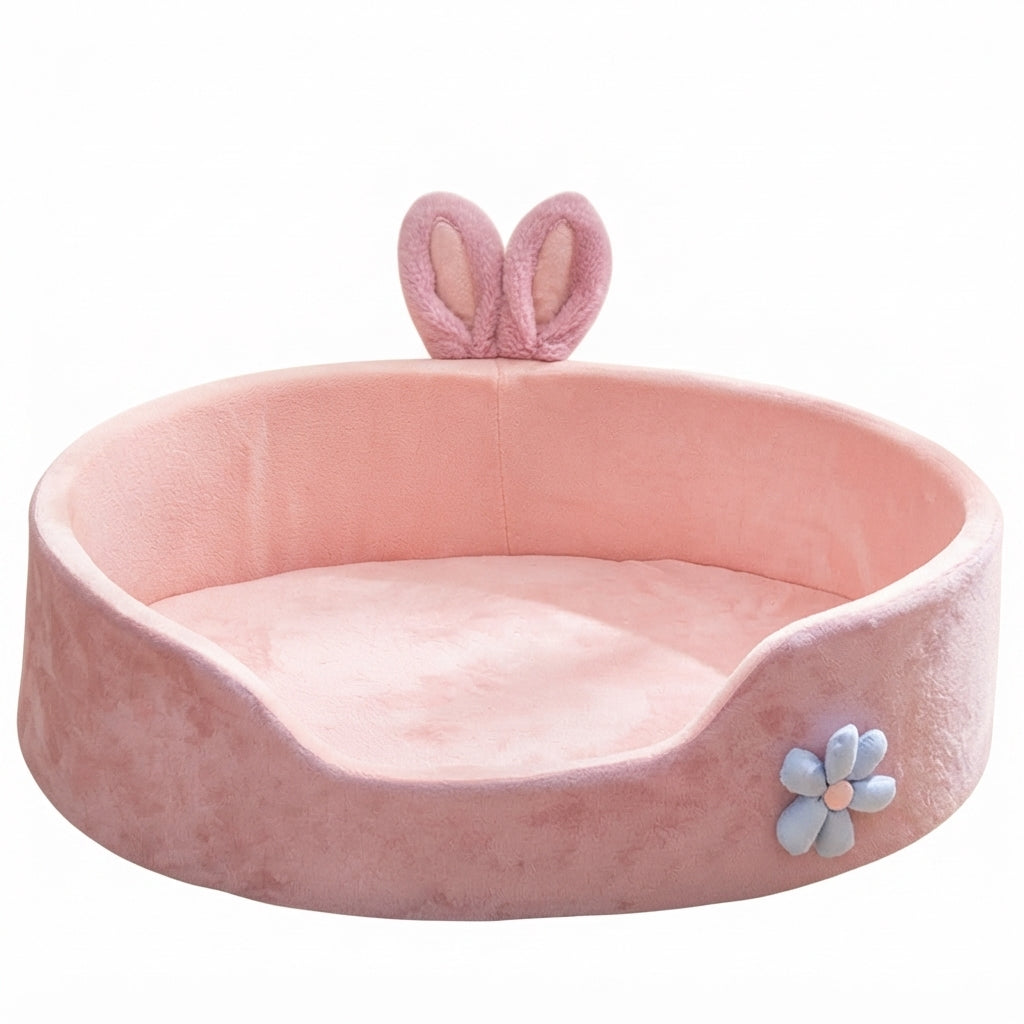Pink bed for dogs with bunny ears: a round, high-sided plush bed with a pale blue flower on the front