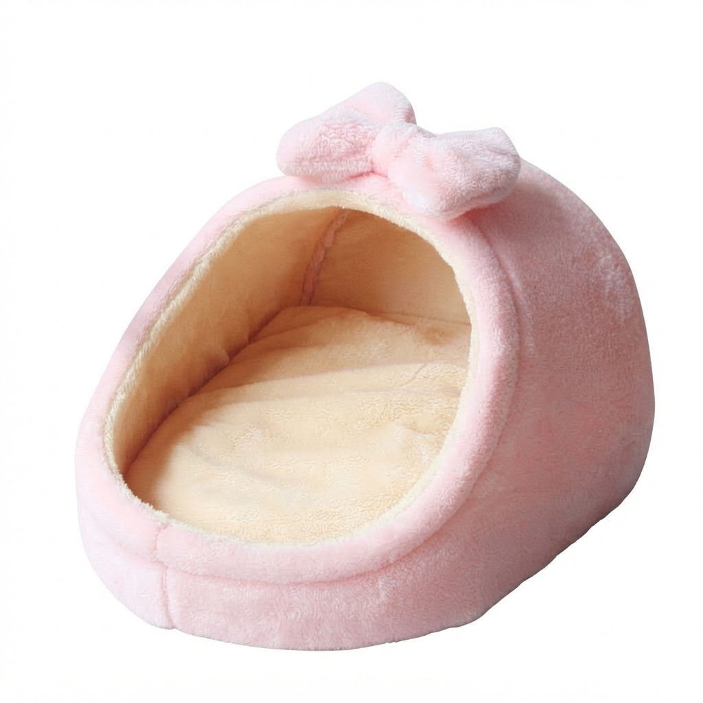 Pink cat bed in pale pink plush, a half-covered nest with a bow on top and a beige cushion inside
