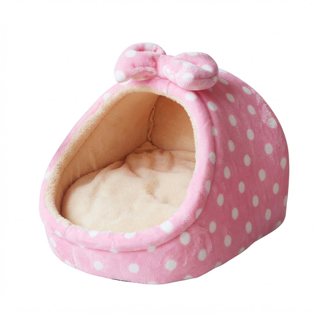 Pink cat bed in pink dots: pink plush with white spots, a matching bow on top and a beige cushion