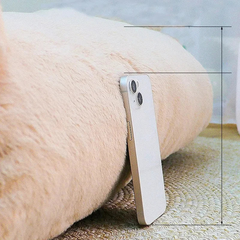 Close-up of the thick plush sofa cat bed cushion with a smartphone standing beside it for scale
