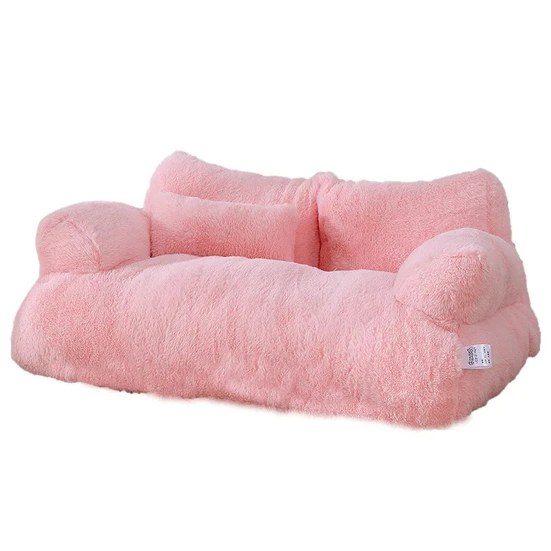 Plush two-seater sofa cat bed in pink faux fur with rounded armrests, a split backrest and a small pillow