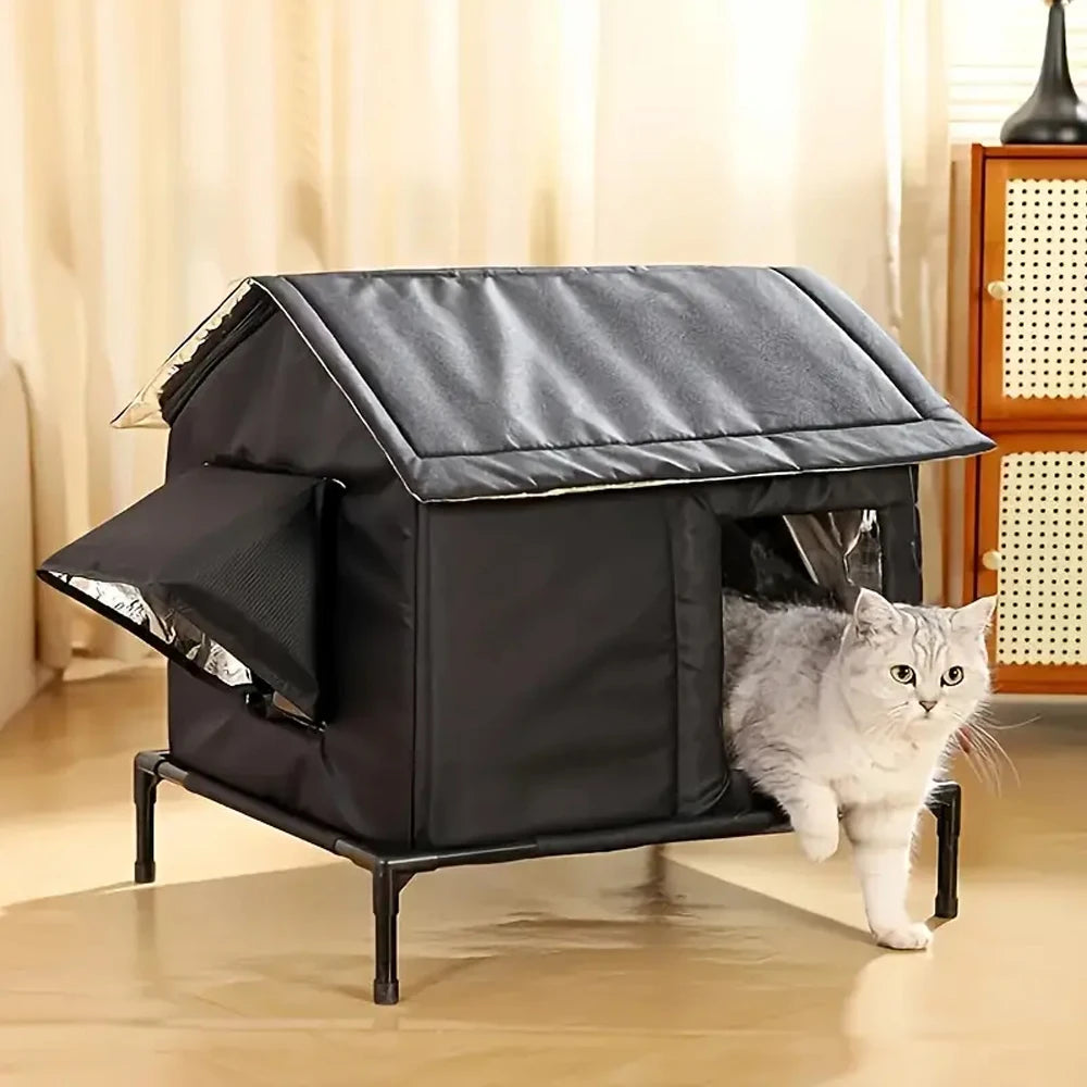 Silver tabby cat stepping out of the clear front door of a black raised cat shelter on a wooden floor indoors