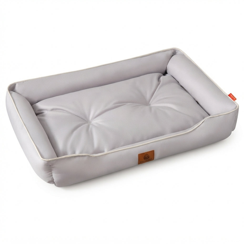 Rectangular dog bed in plain light grey with raised padded sides and a tufted cushion