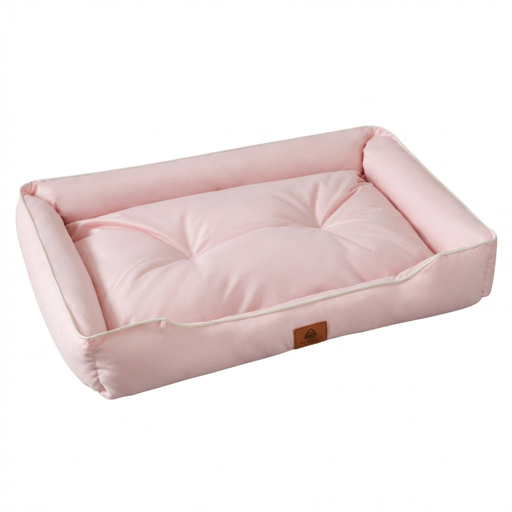 Rectangular dog bed in plain pale pink with raised padded sides and a tufted cushion