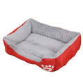 Washable dog bed in red Oxford cloth, rectangular with a grey plush lining and a white paw print on the front