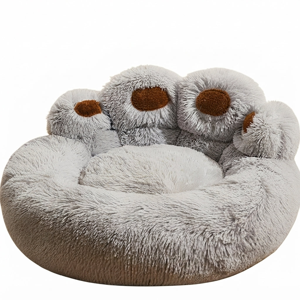 Paw-shaped round dog bed in light grey long plush with four brown toe pads along the raised back