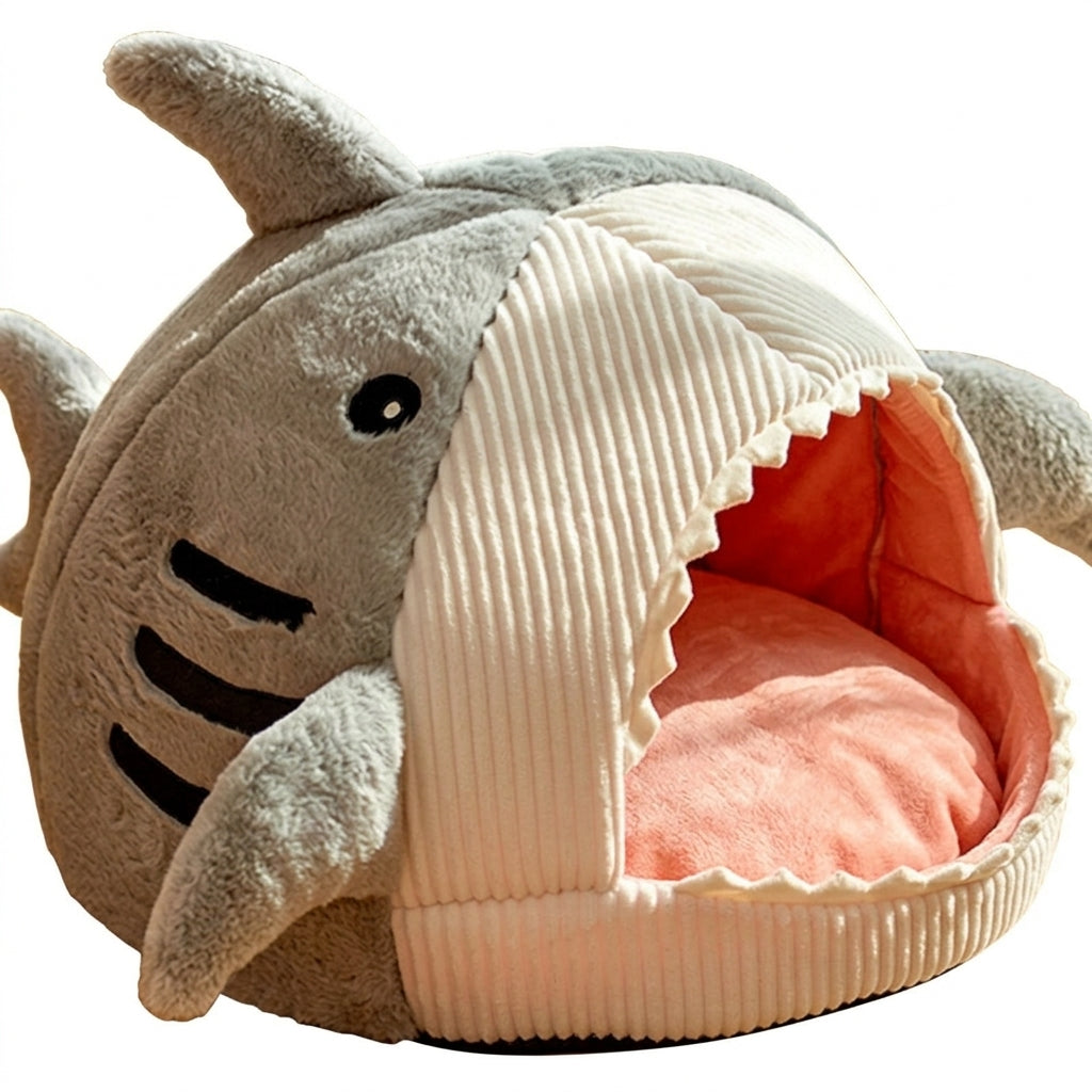 Shark cat bed cave in Grey plush with a cream corduroy belly, fins, a toothed opening and a pink cushion inside