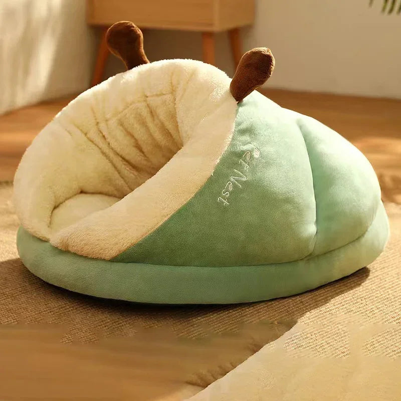 Slipper-shaped dog bed in green with a cream plush lining and two brown antlers, on a rug in a sunlit room