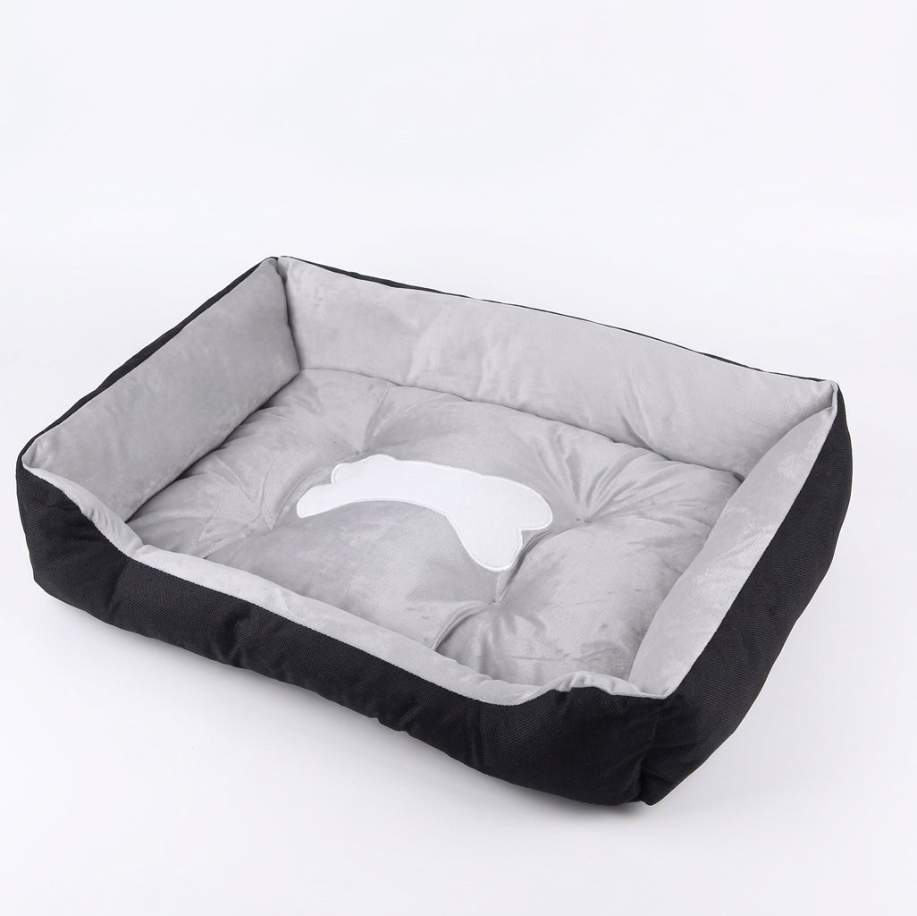 Rectangular dog bed in black bone design: black fabric sides, a light grey lining and a white bone patch