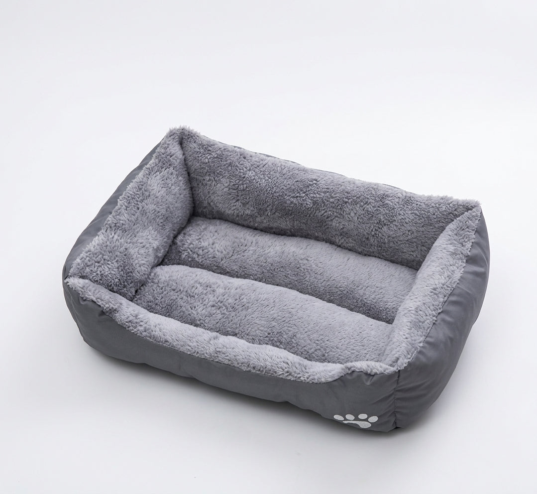 Rectangular dog bed in grey paw design: grey fabric sides with a white paw print and a grey plush lining