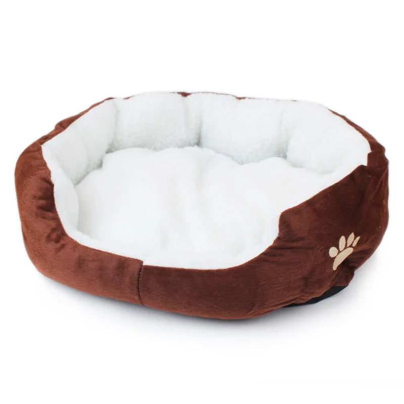 Oval pet bed in coffee brown with a white fleece lining and a beige embroidered paw print on the side