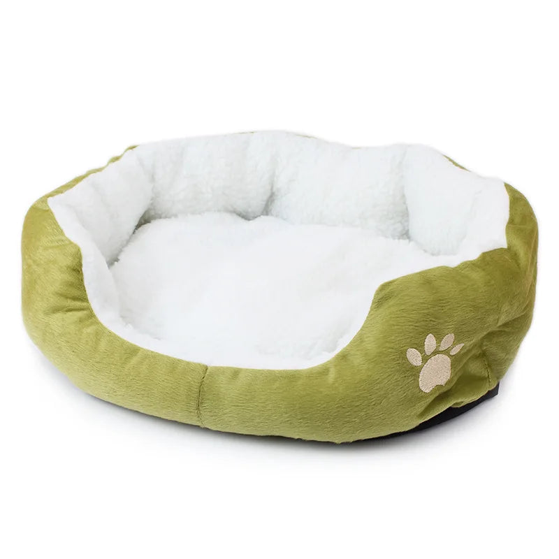 Oval pet bed in green, an olive shade, with a white fleece lining and a beige embroidered paw print