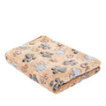 Small dog bedding in brown footprints coral fleece, a folded tan blanket with grey and pale blue paw prints