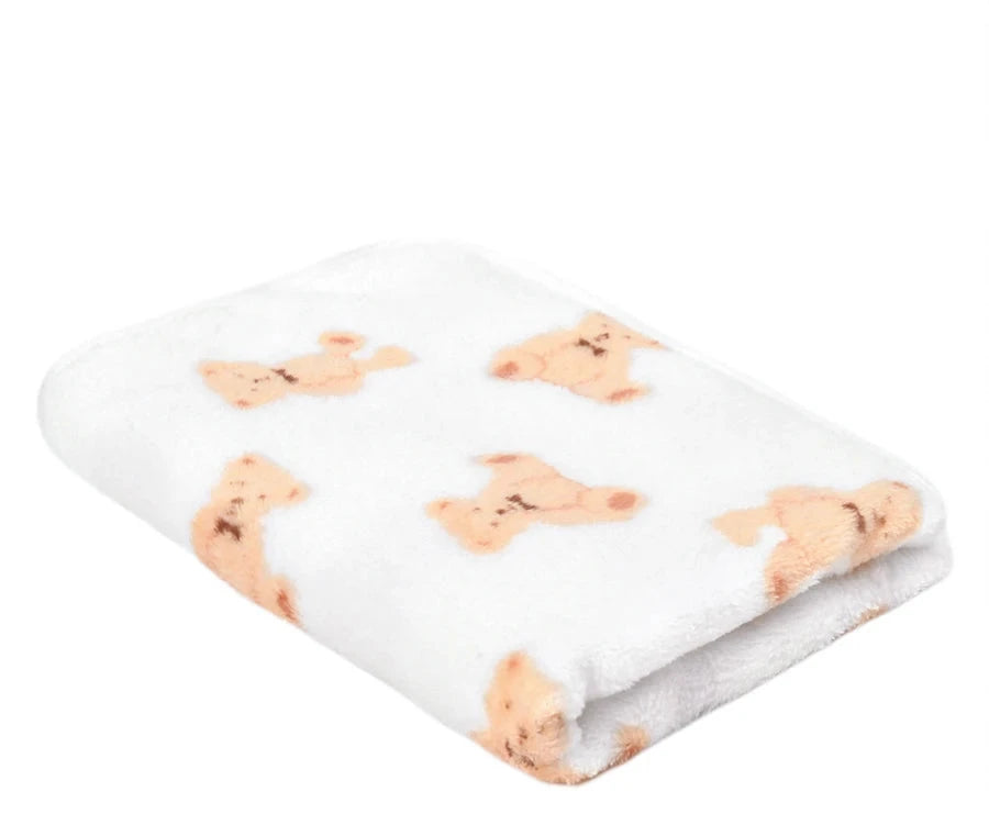 Folded white coral fleece blanket printed with small beige teddy bears
