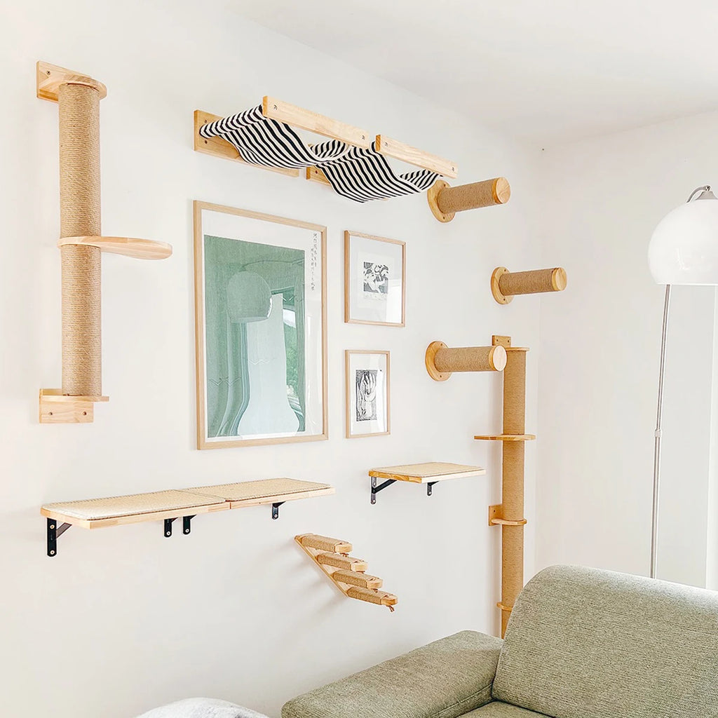Wooden cat wall pieces around picture frames: sisal posts, a striped hammock, bracket shelves and a small ladder