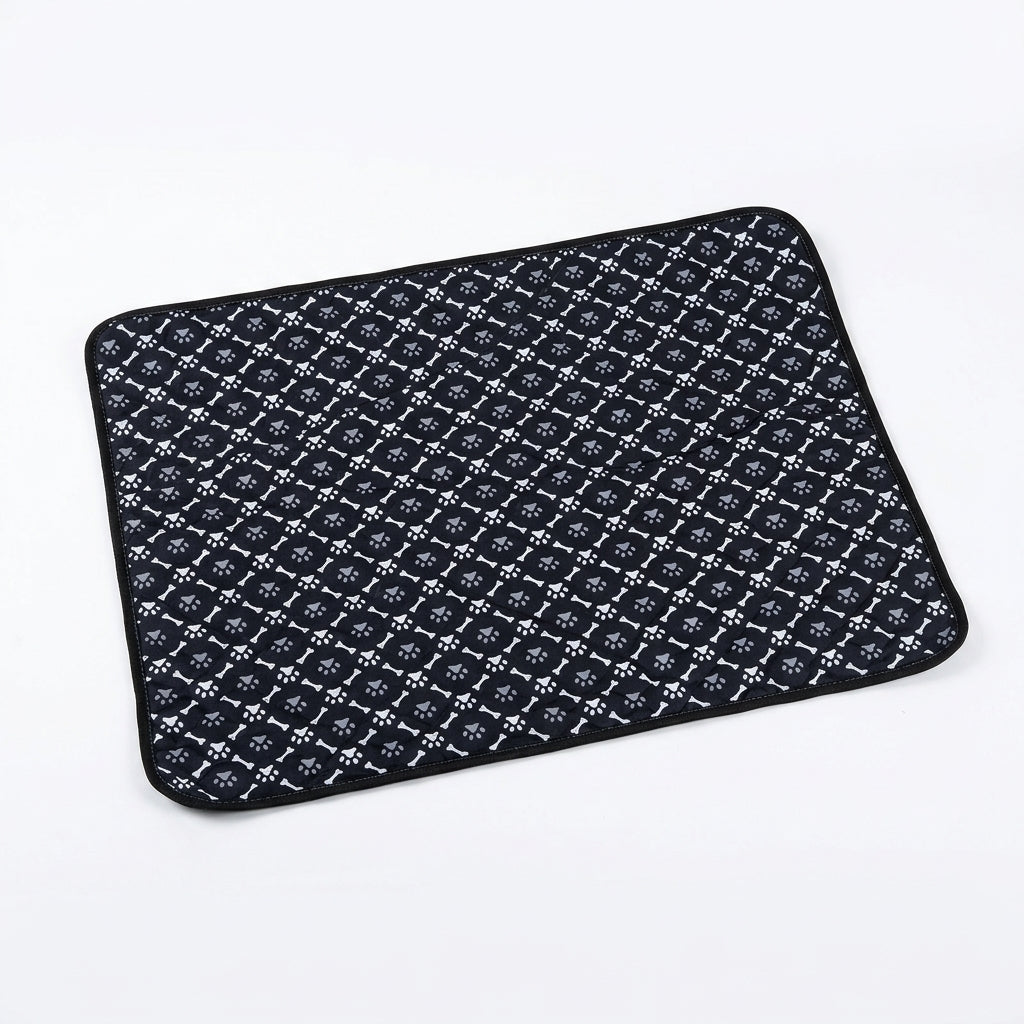 Black quilted pet mat with a repeating pattern of white bones and grey paw prints