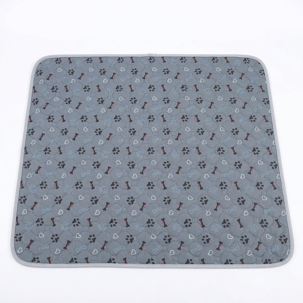 Grey quilted pet mat printed with small black paw prints, dark bones and white outline hearts