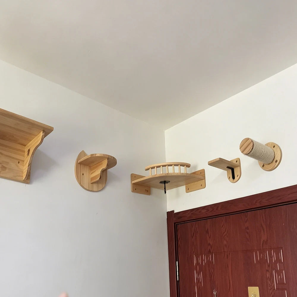 Assorted wooden cat wall pieces fixed high in a room corner: a large shelf, two perches, a railed platform and a sisal post